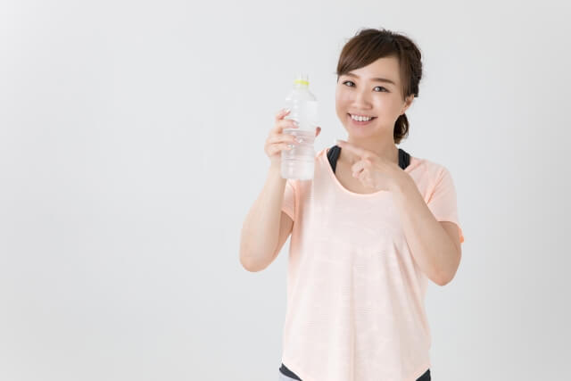 笑顔で水を飲む女性