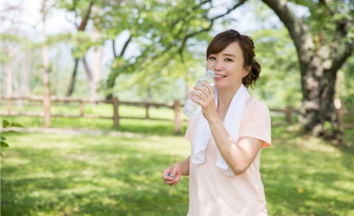 ペットボトルの水を飲む女性